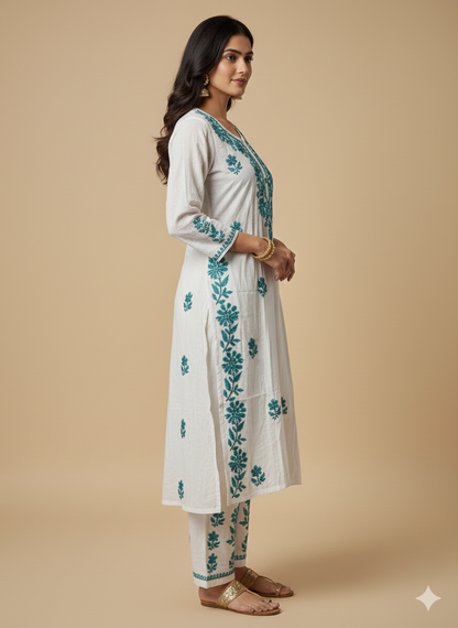 Woman wearing a white kurta with green floral embroidery on a beige background