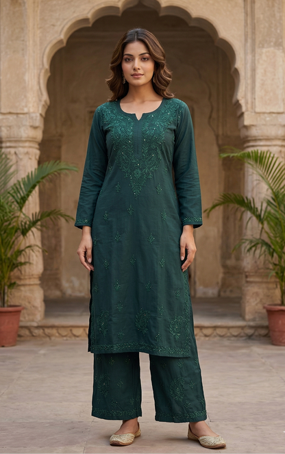 Woman wearing a green traditional outfit standing in front of an archway with plants.